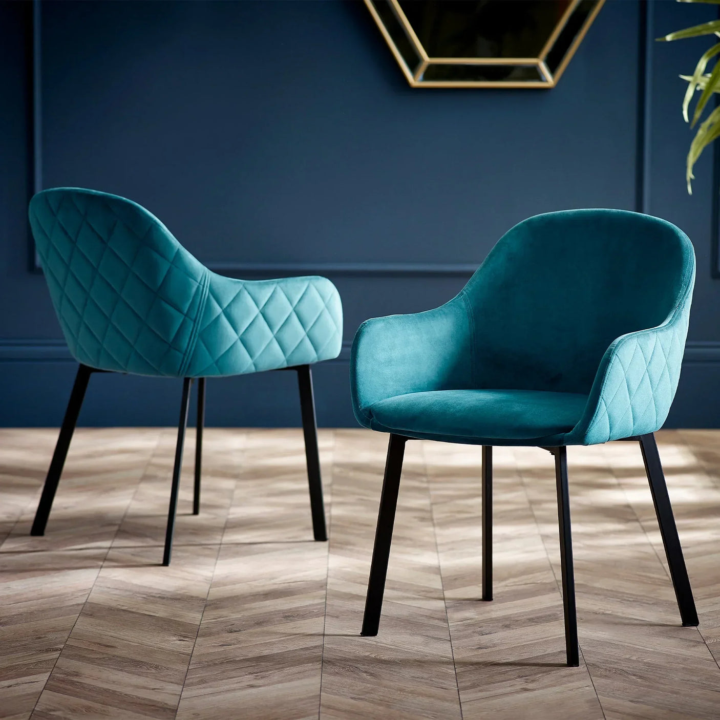 Teal velvet dining chair with black legs and quilted back in modern room