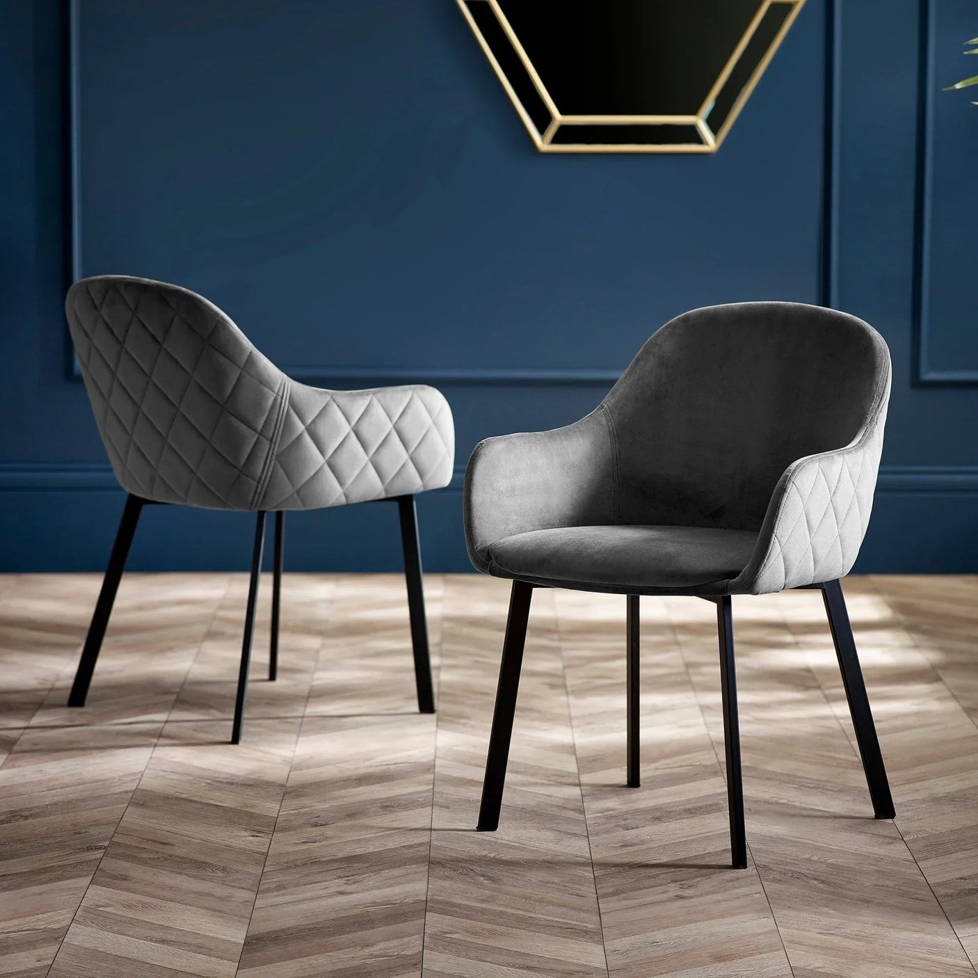 Grey velvet dining chairs with diamond quilted backrest and black metal legs on wood floor