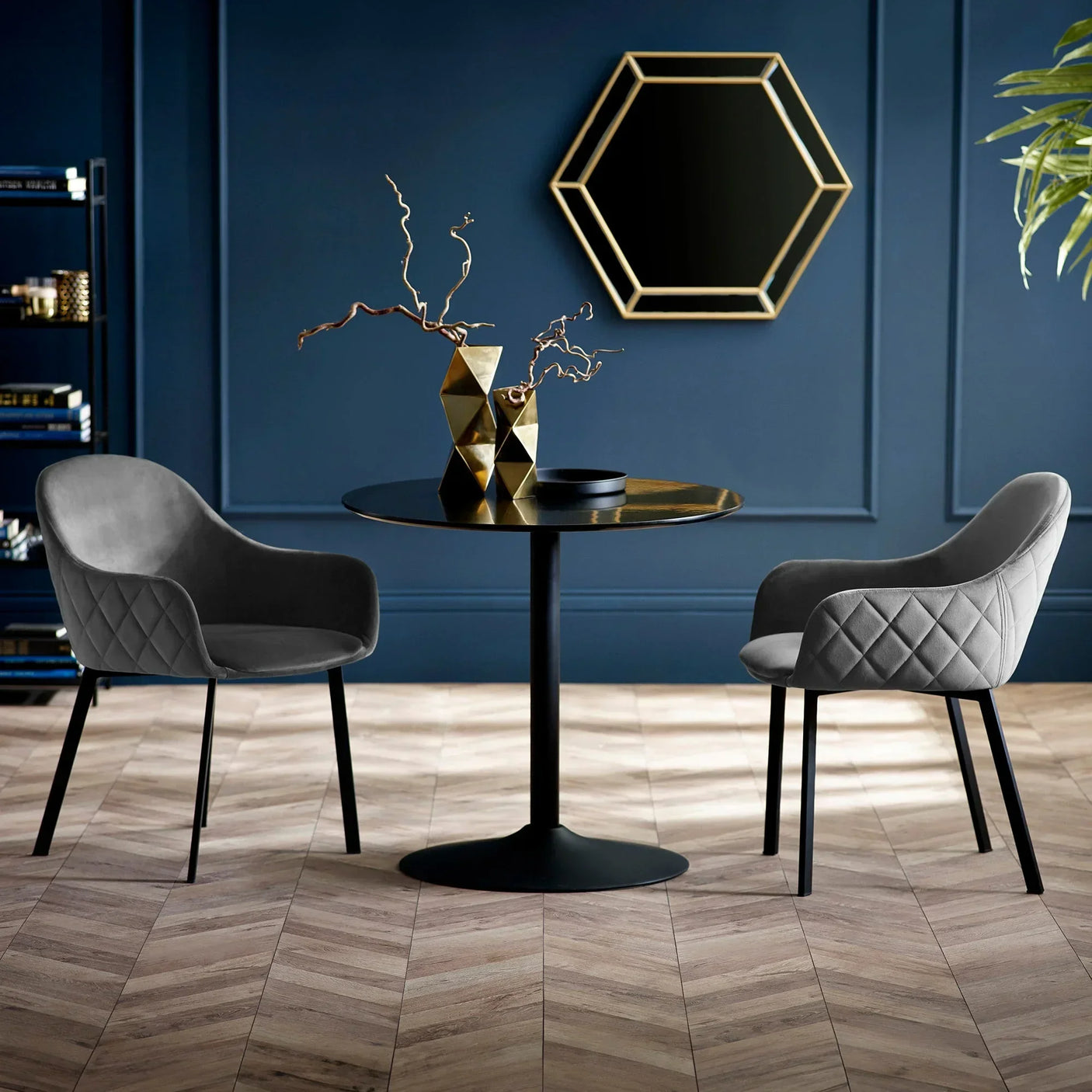 Velvet dining chairs with diamond stitching and black metal legs at round black table