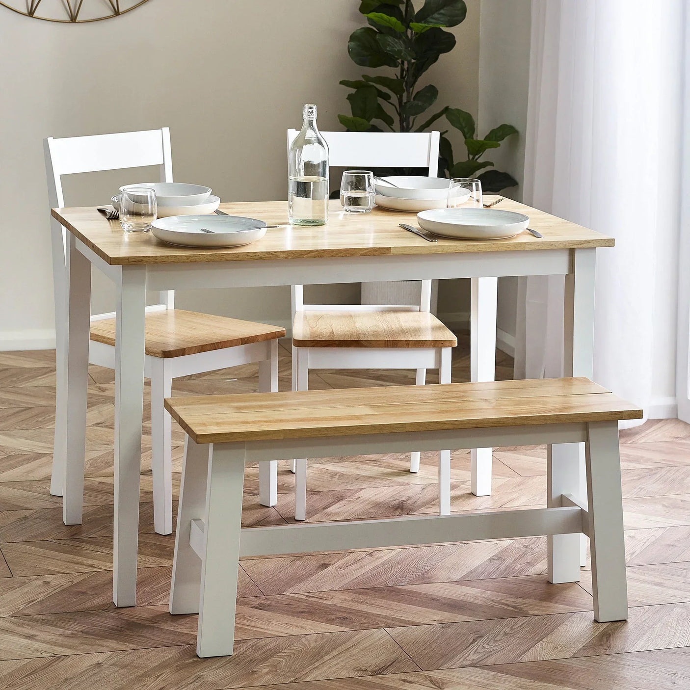 Small dining table set with two chairs and bench in light wood and white finish, set for two