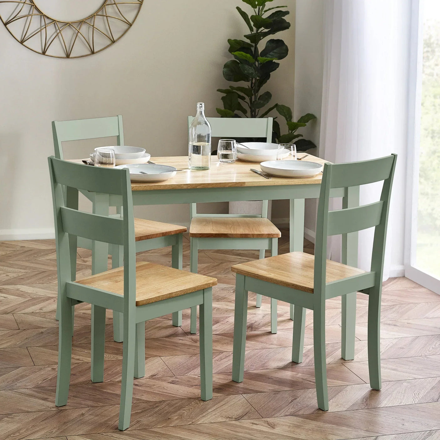 Light green wooden dining table set with four chairs in a bright modern dining room