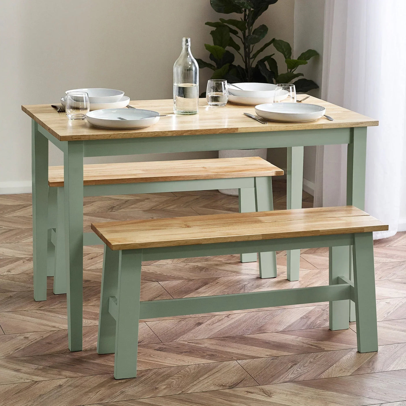 Wood dining table set with two benches, light oak tops and sage green legs, set for four