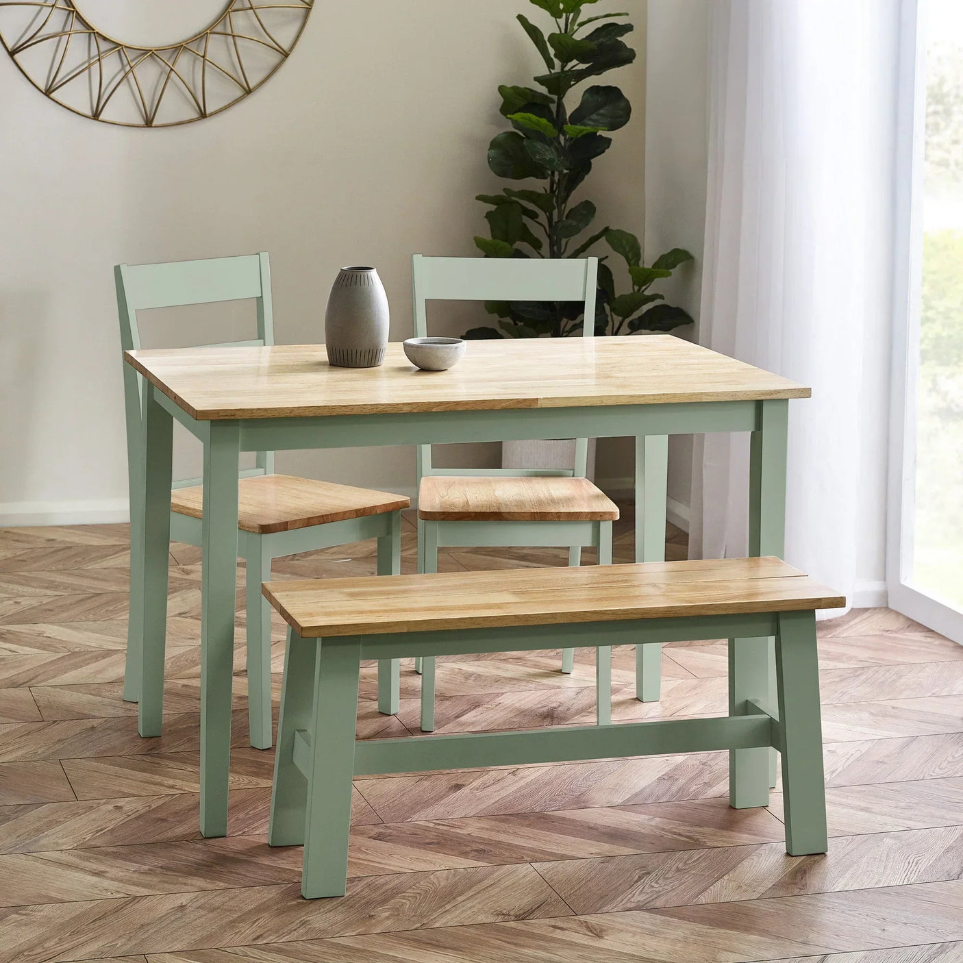 Green wooden dining table set with two chairs and a bench, oak tops, in bright room