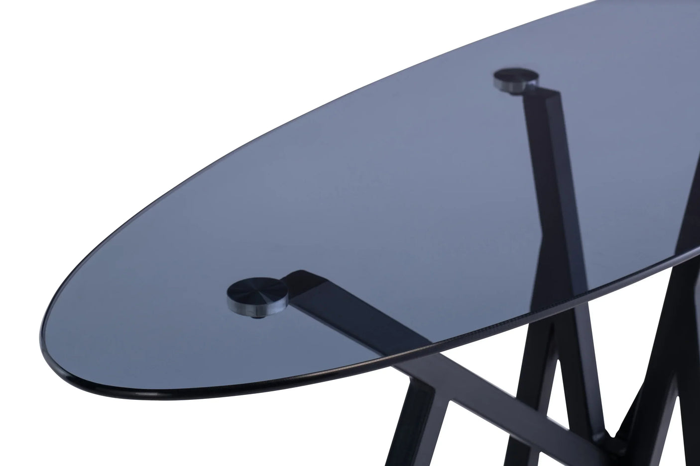 Black glass dining table with oval top and modern metal legs, close-up of corner