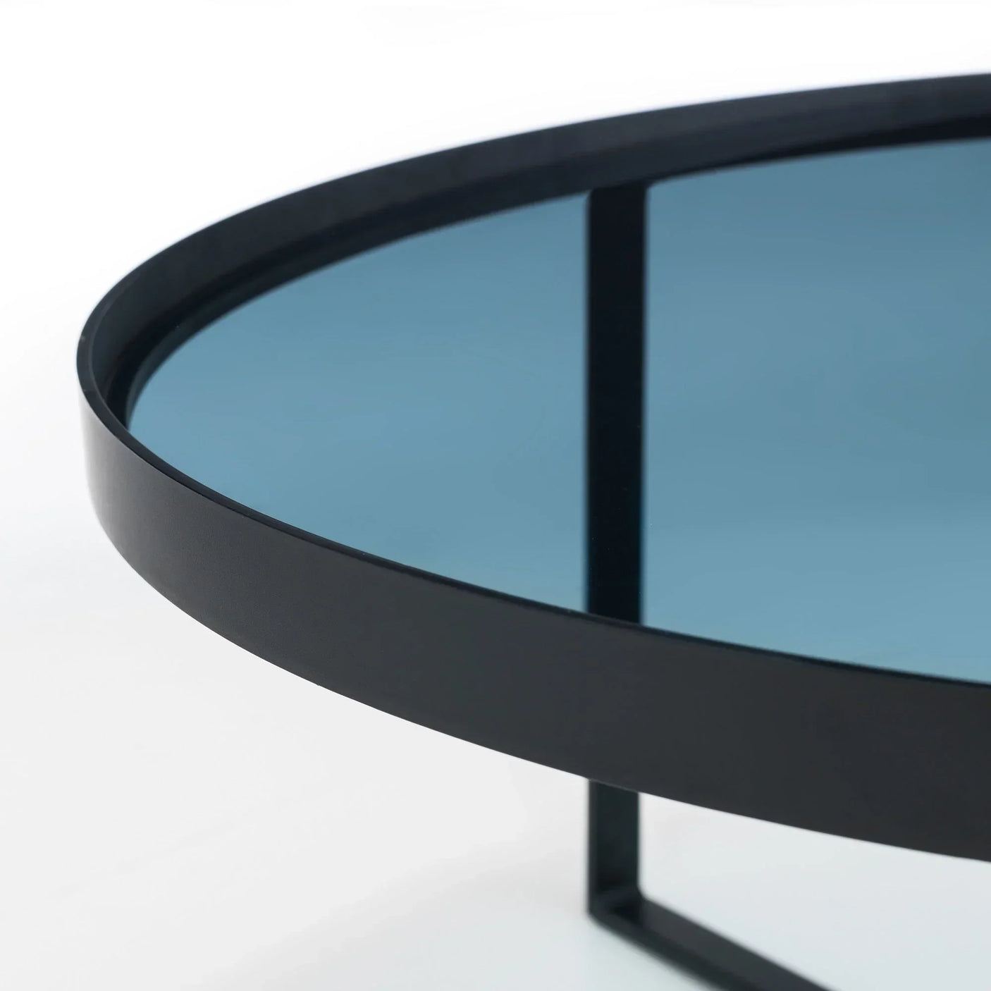 Close-up of smoked glass coffee table with black metal frame and round edge detail