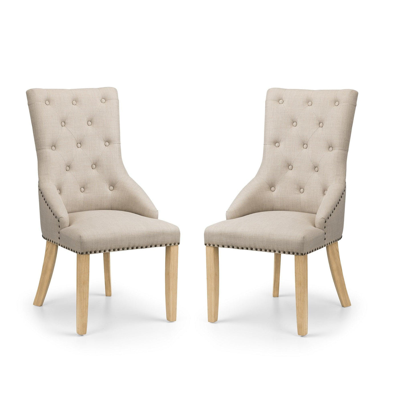 Pair of button back dining chairs with beige upholstery and wooden legs on white background
