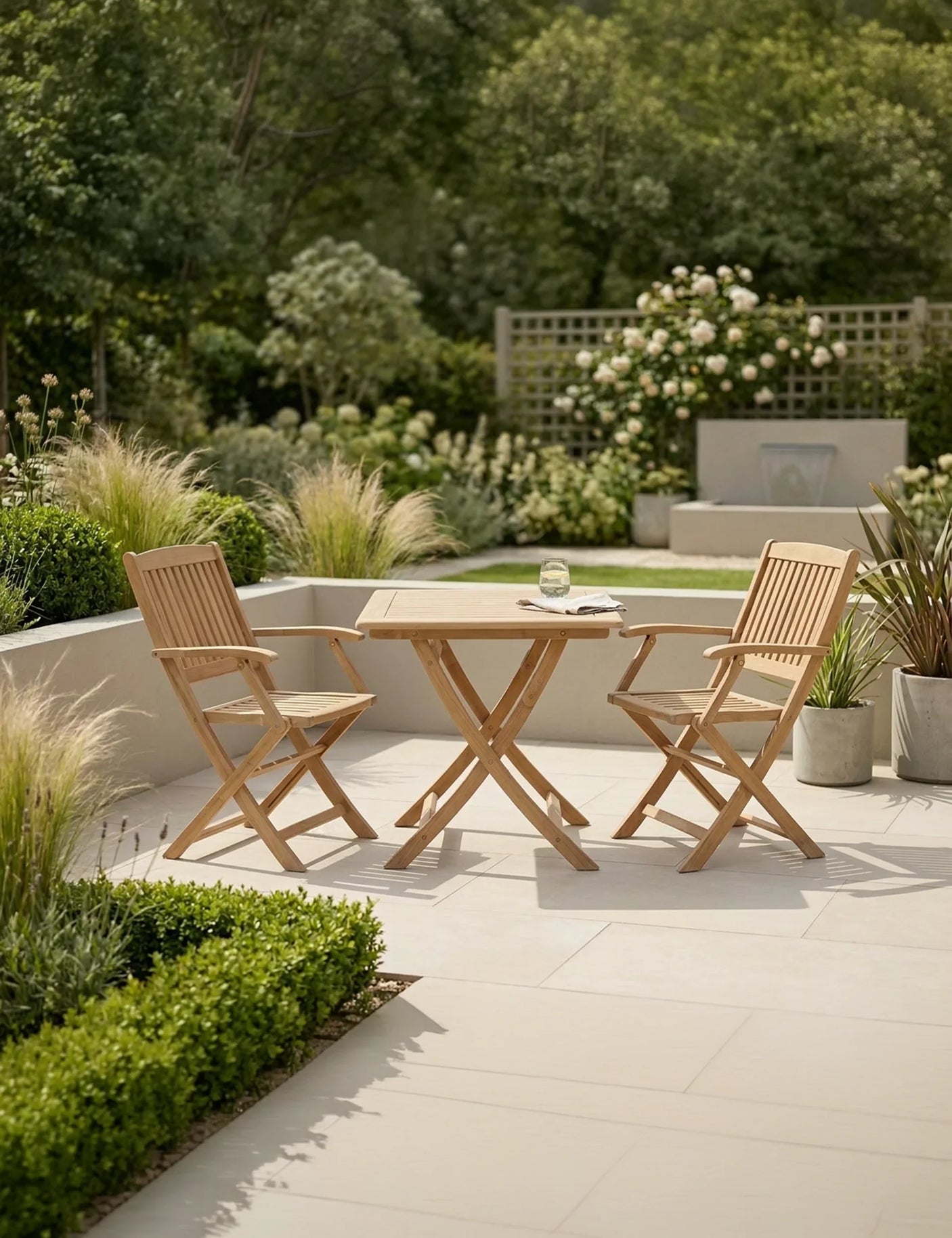 Wooden garden bistro set with folding chairs and table on patio, surrounded by greenery