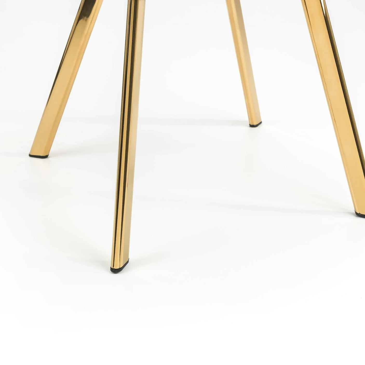 Gold metal legs of dining chair on white background, close-up angle