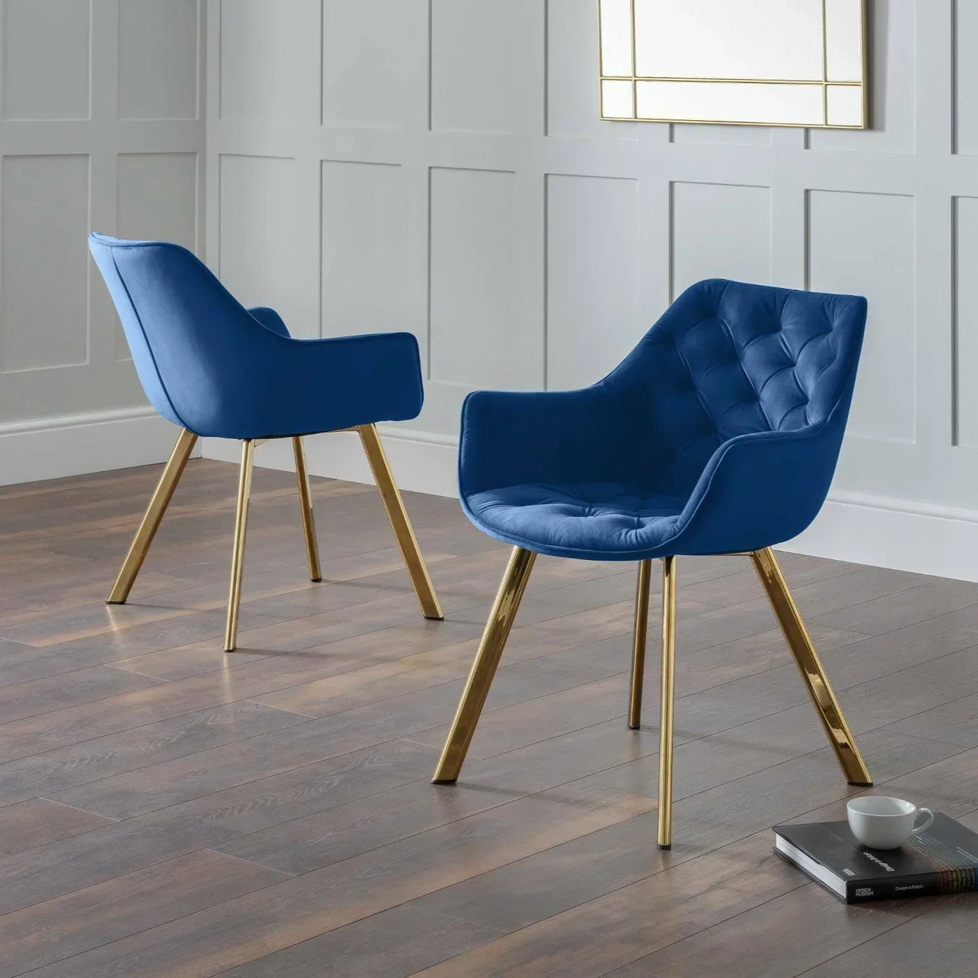 Blue velvet accent chairs with gold legs in modern room on wood flooring