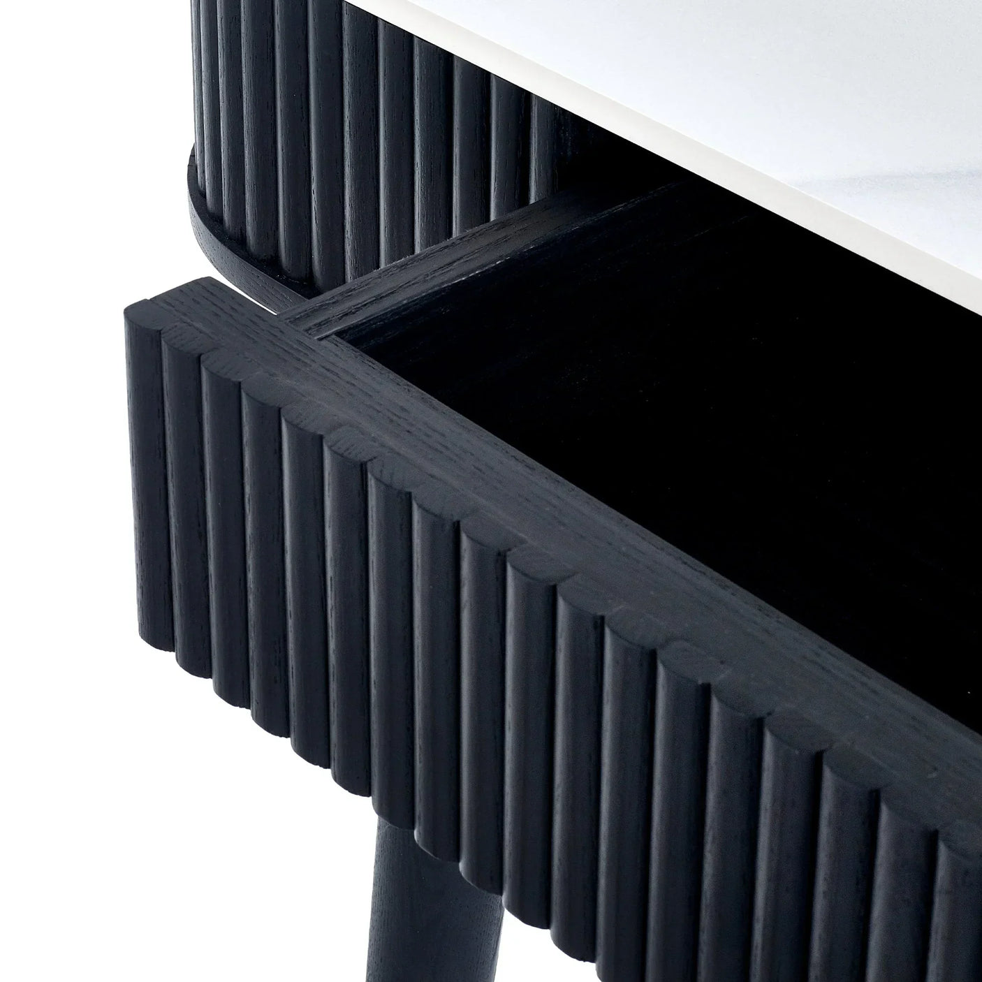 Black fluted dining table with visible stone top and open drawer detail