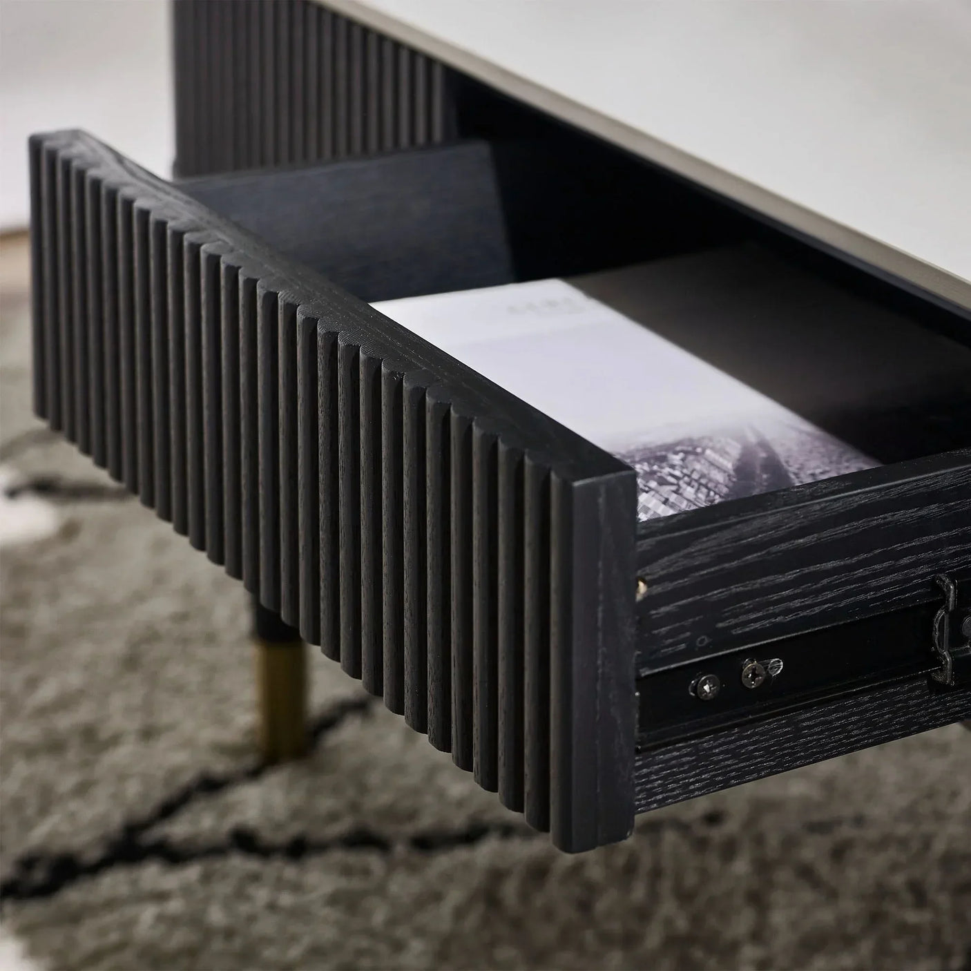 Black fluted coffee table with open drawer showing wood texture and storage detail
