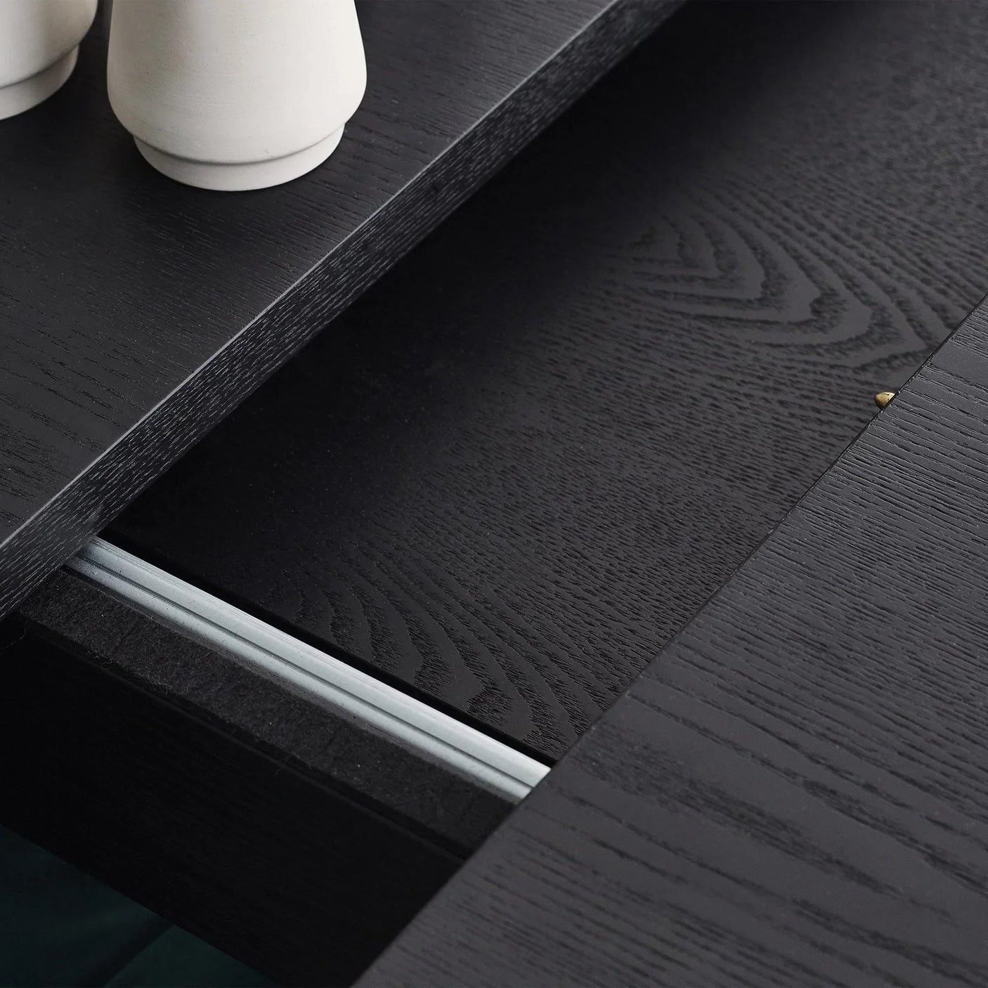 Black fluted extending dining table close-up showing wood grain and extension mechanism