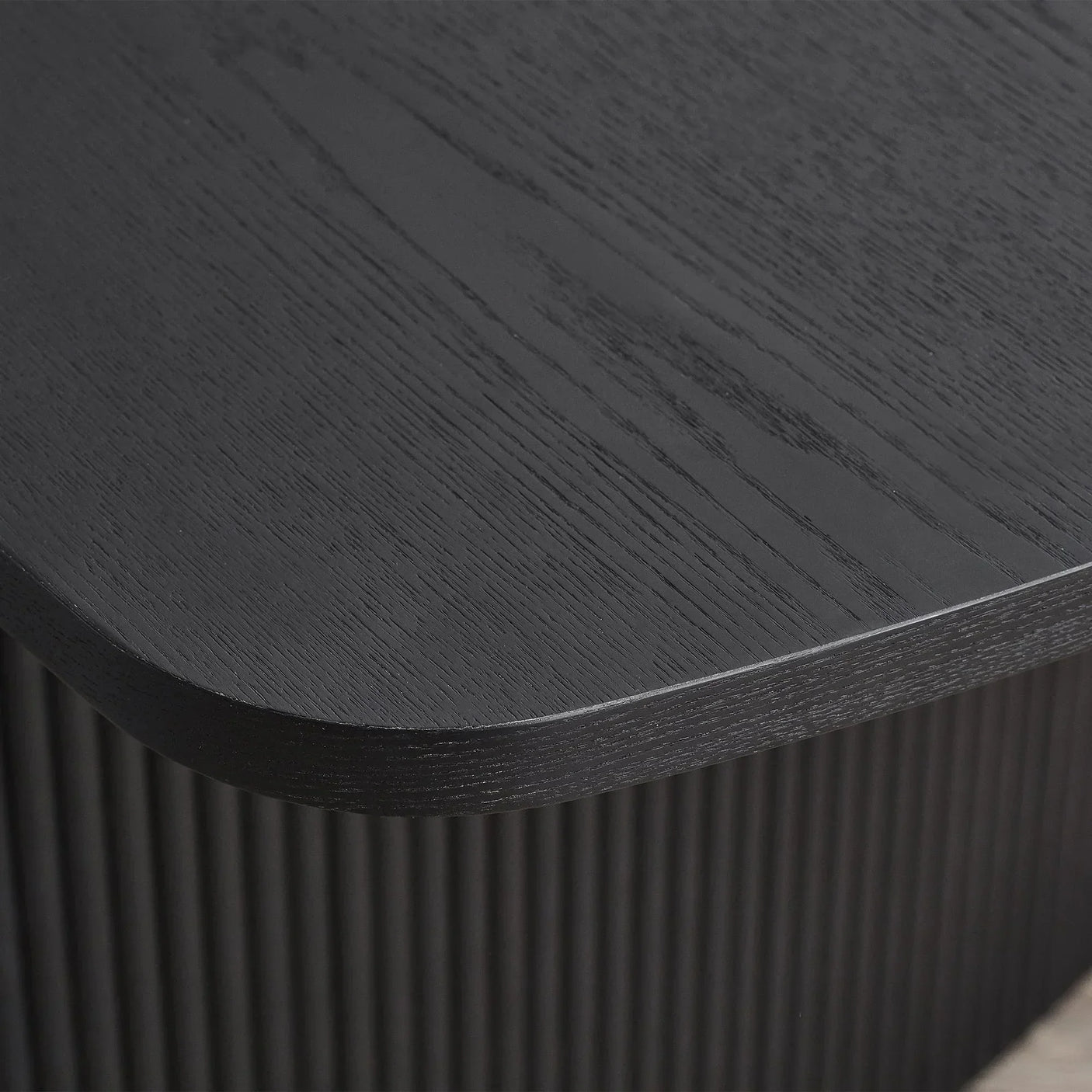 Close up of black fluted extending dining table corner with wood grain detail
