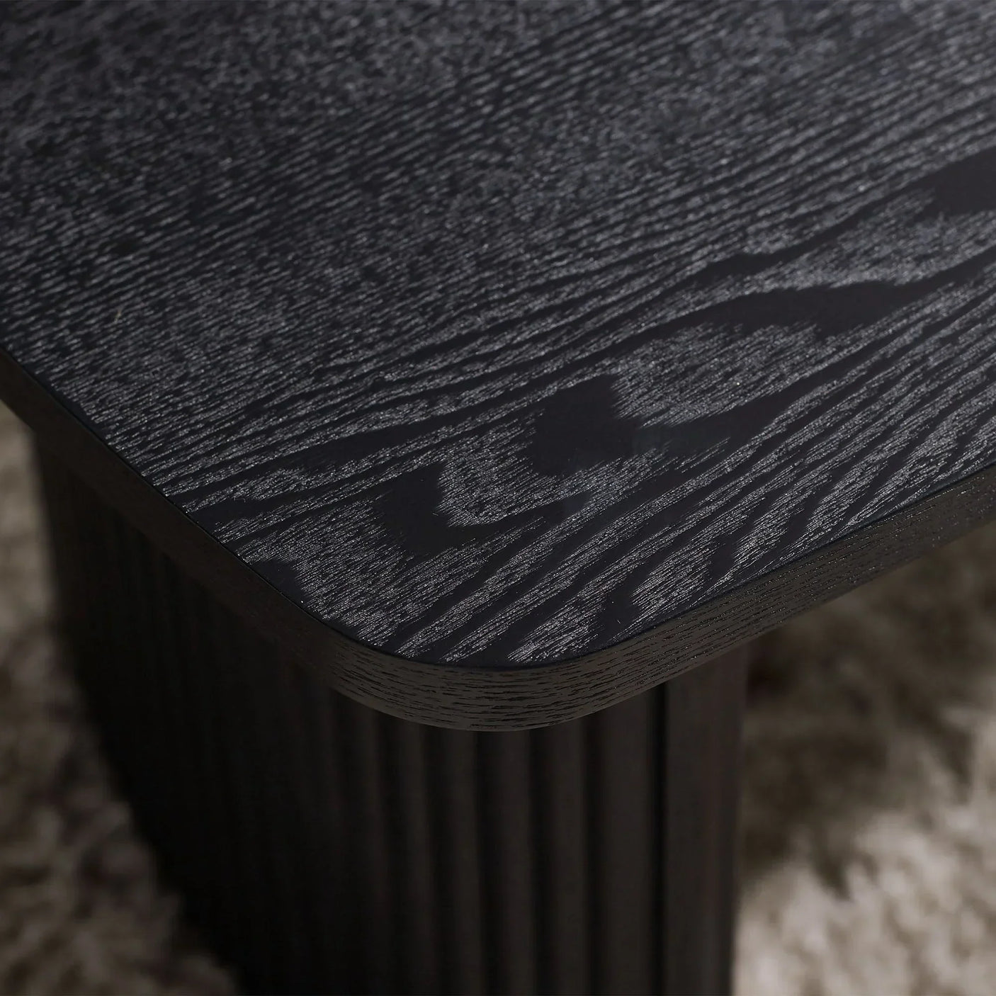 Black fluted compact coffee table corner detail showing wood grain and textured finish