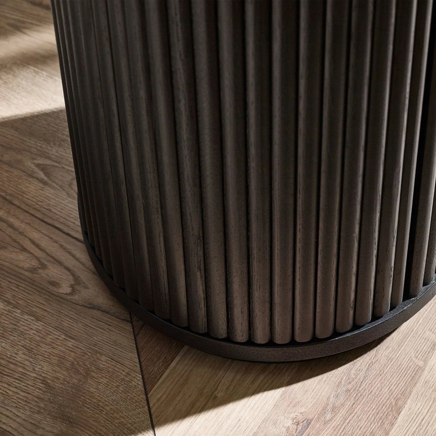 Black fluted side table base detail on wooden floor