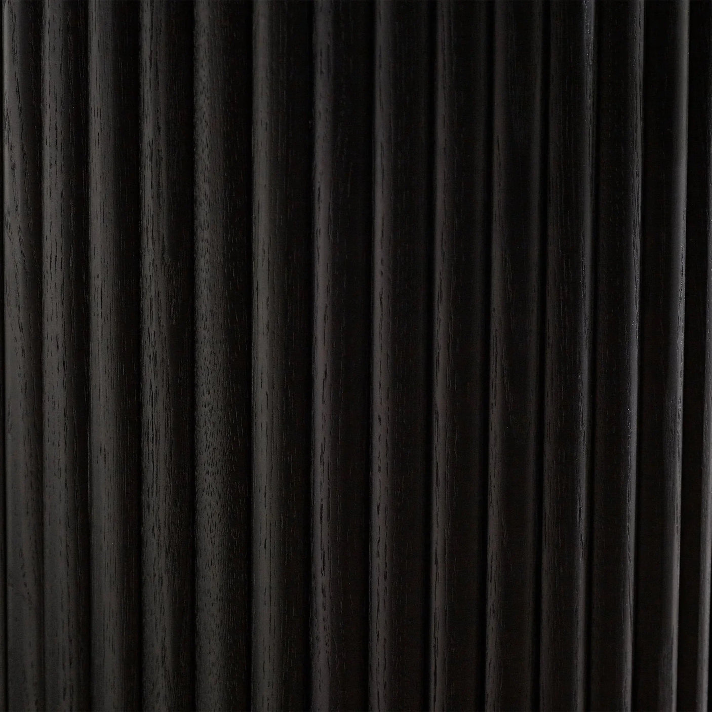 Black fluted wood detail on side table door, closeup showing vertical grooves