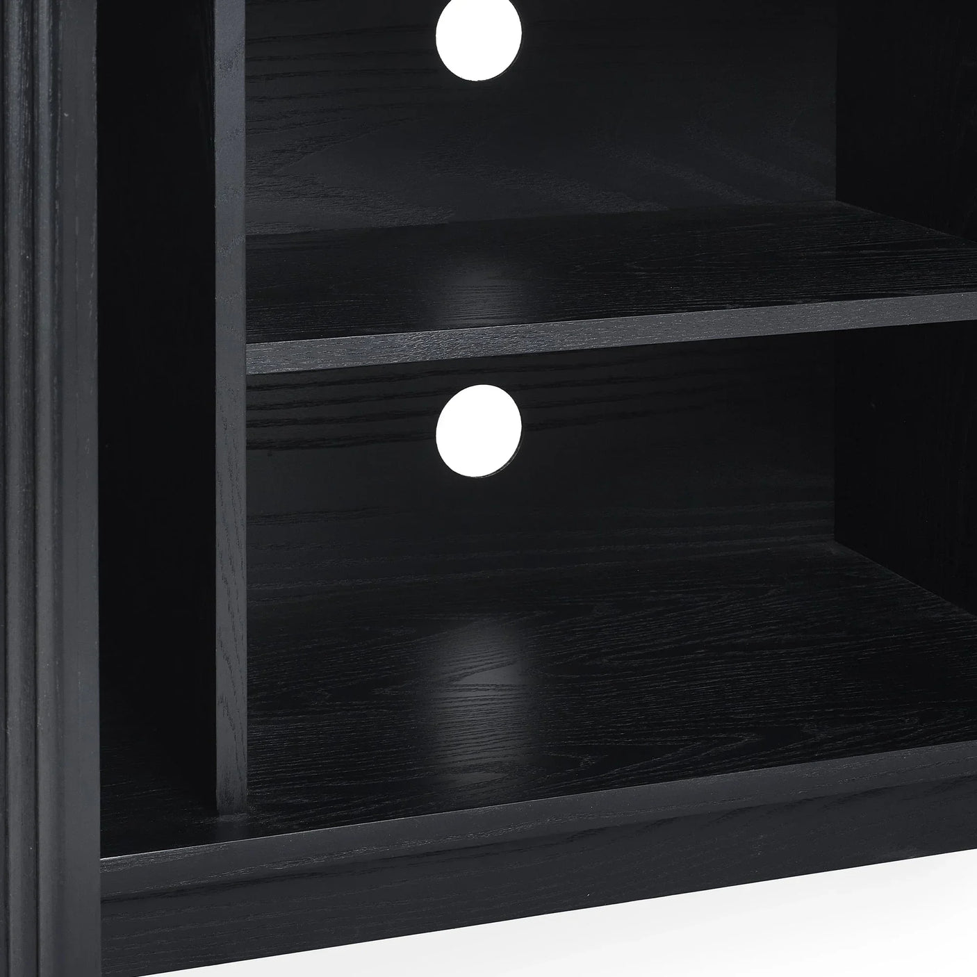 Black fluted TV unit shelf detail with cable management holes and wood grain finish