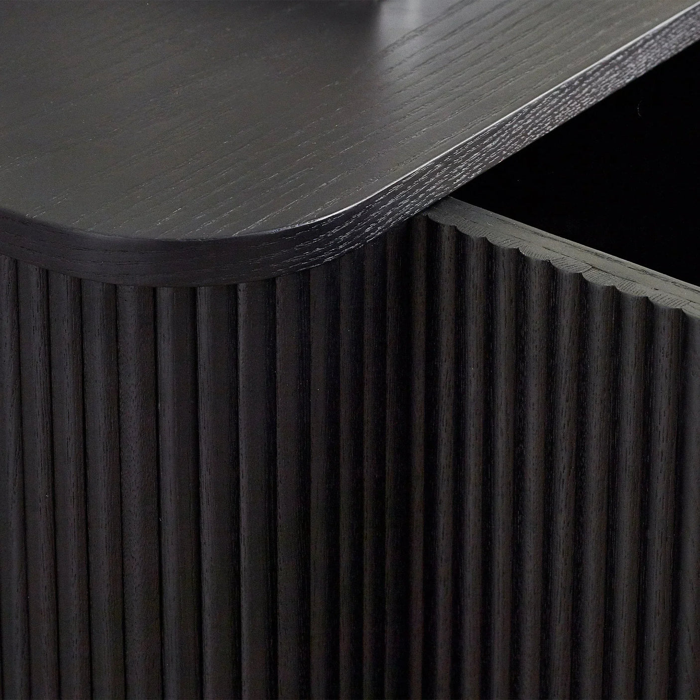 Close up of black fluted sideboard with rounded corner and textured wood finish