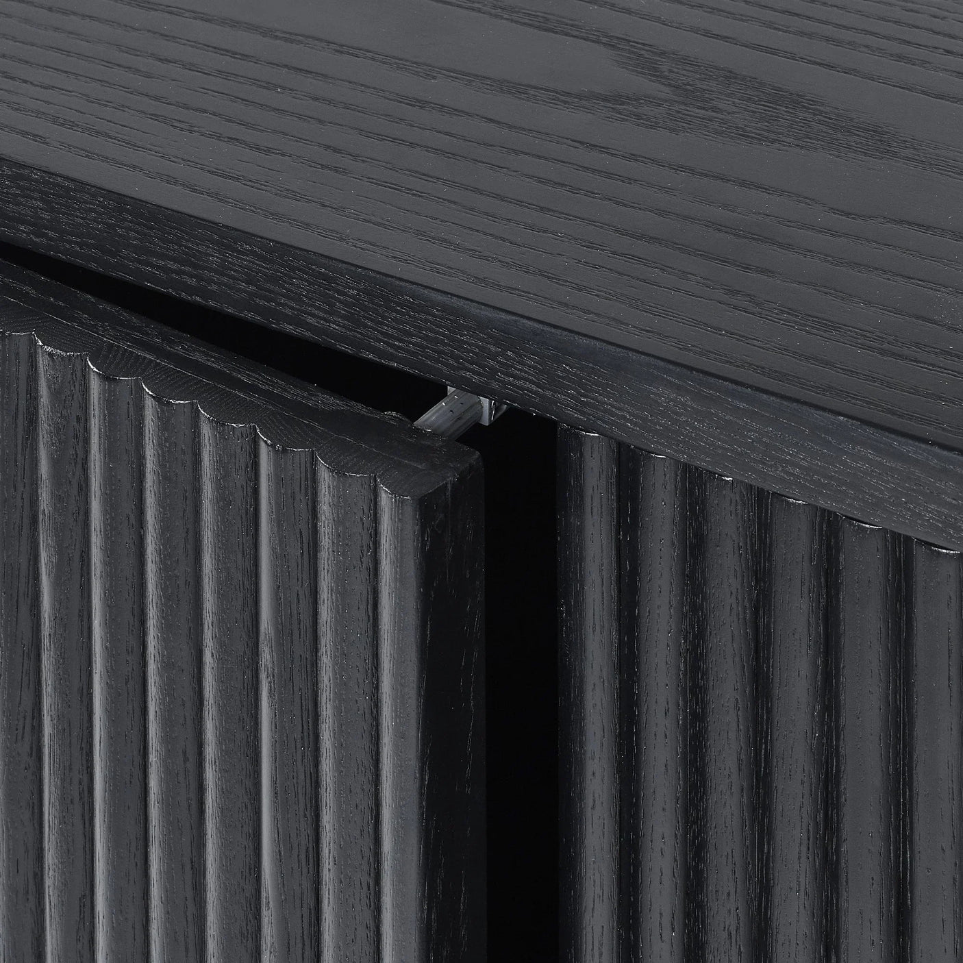 Black fluted sideboard cabinet door with textured wood grain and open hinge detail