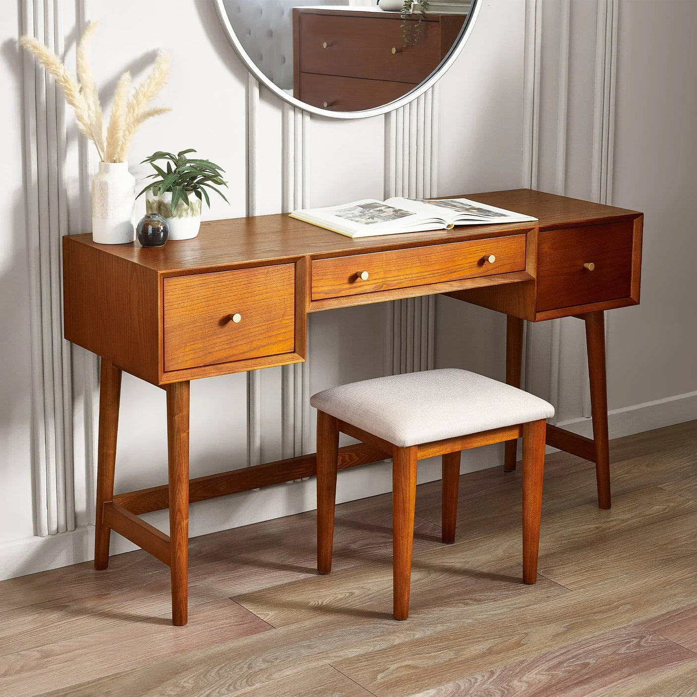 Wooden dressing table and stool set with drawers, mirror, and decor in modern bedroom