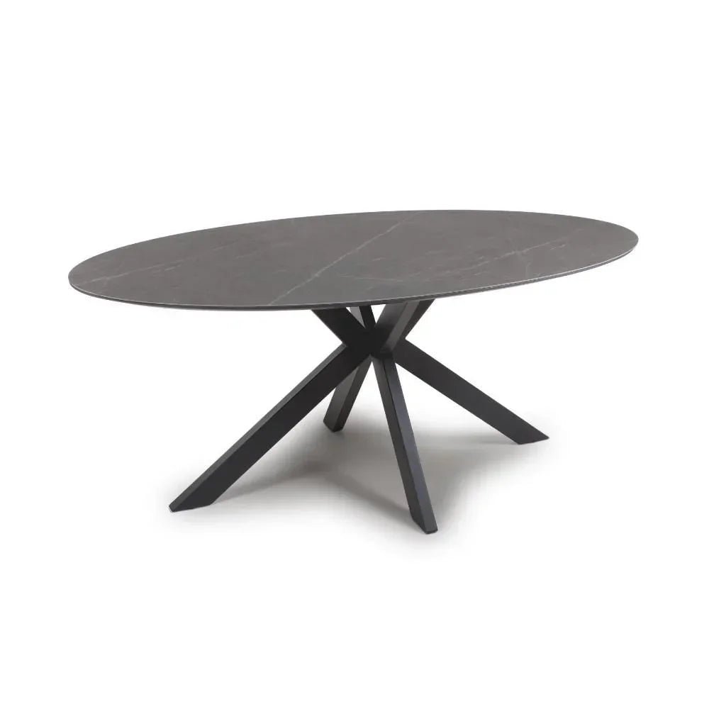 Oval black dining table with angled metal legs and matte finish top