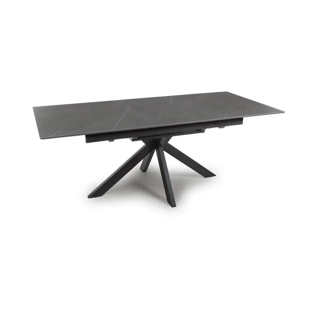 Rectangular black dining table with ceramic top and metal splayed base on white background
