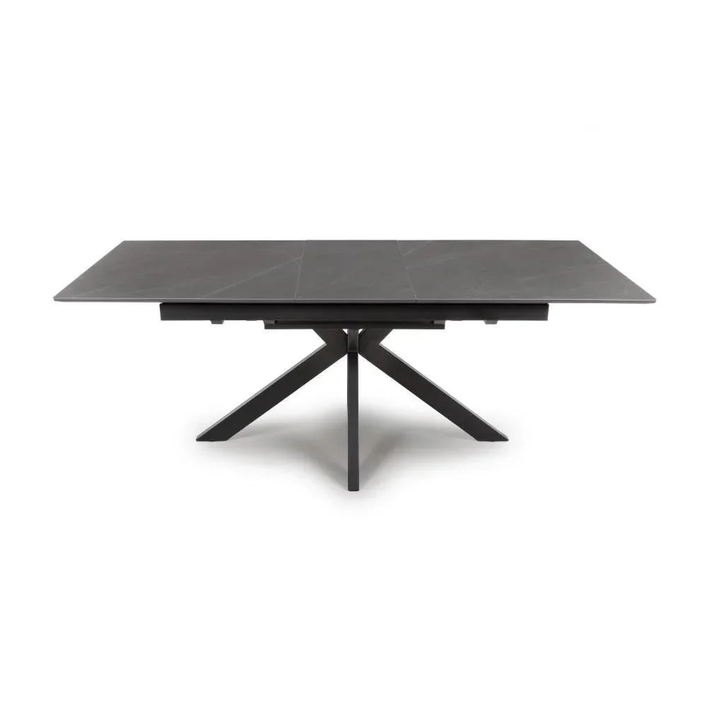 Rectangular black dining table with ceramic top and spider leg base, front angle view