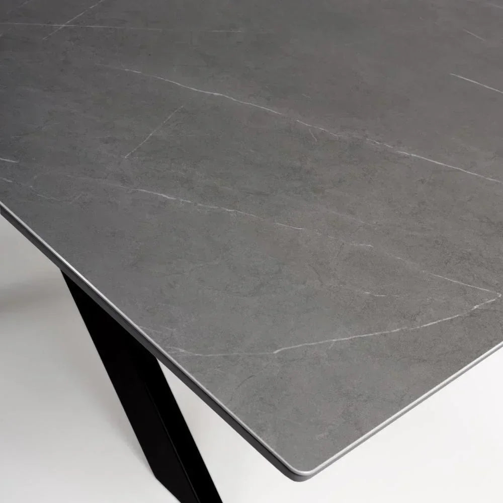Grey ceramic dining table top with black metal legs, angled corner view