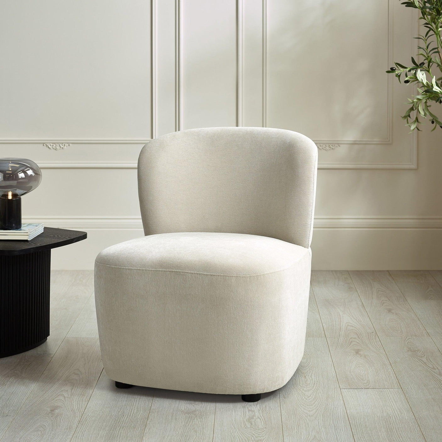Cream upholstered accent chair with curved backrest on light wood floor