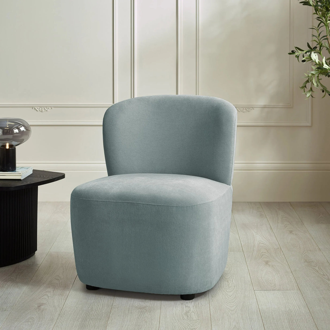 Light grey accent chair with curved backrest in modern living room setting