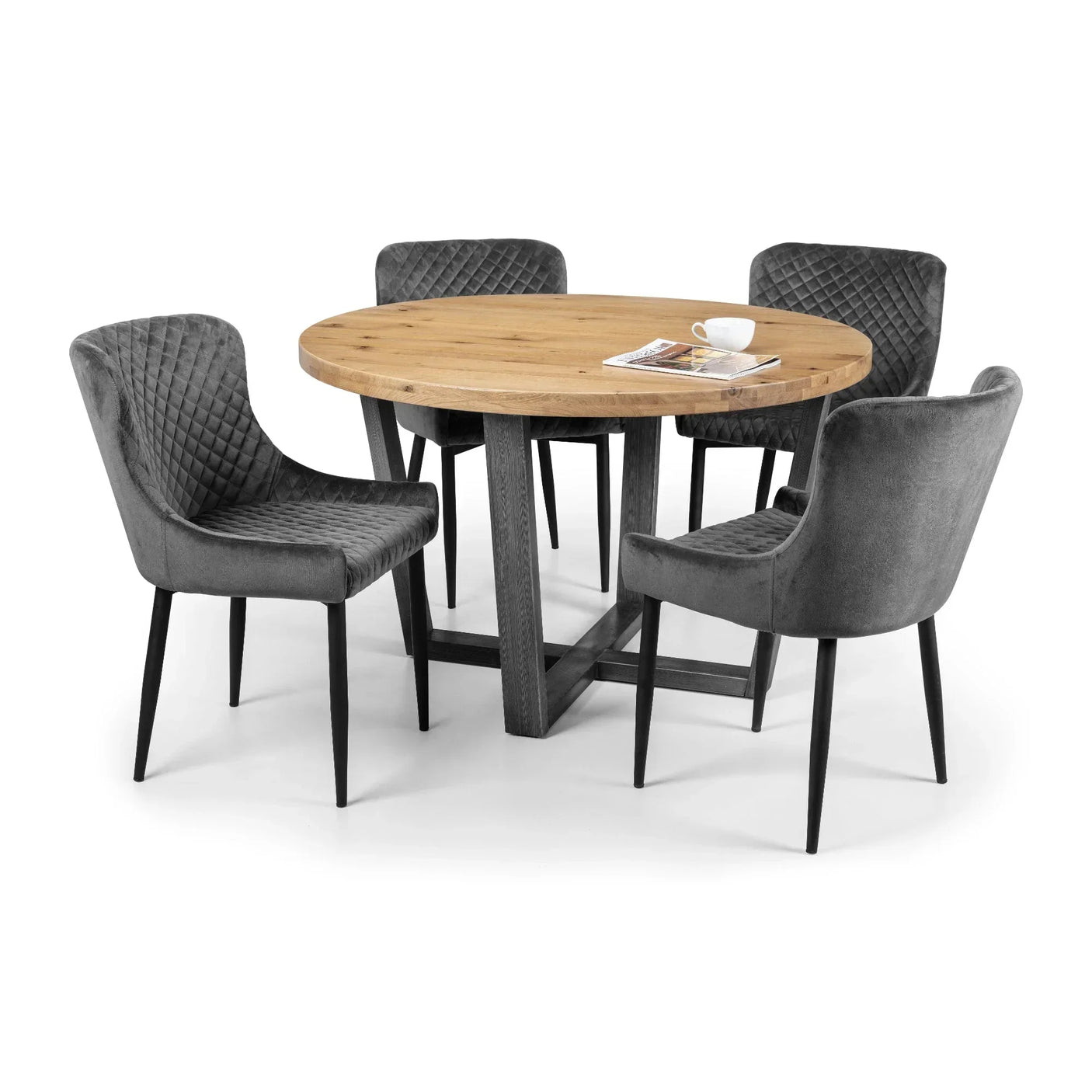 Grey velvet dining chairs with diamond stitching around round wood dining table