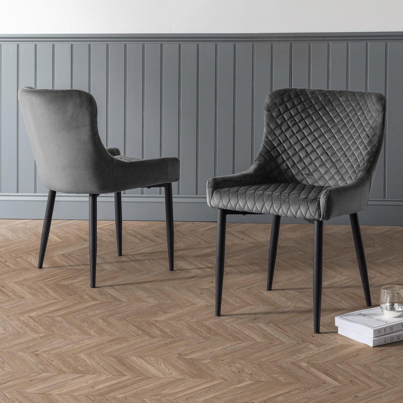 Grey velvet dining chair with quilted backrest on wood floor, side and front views shown