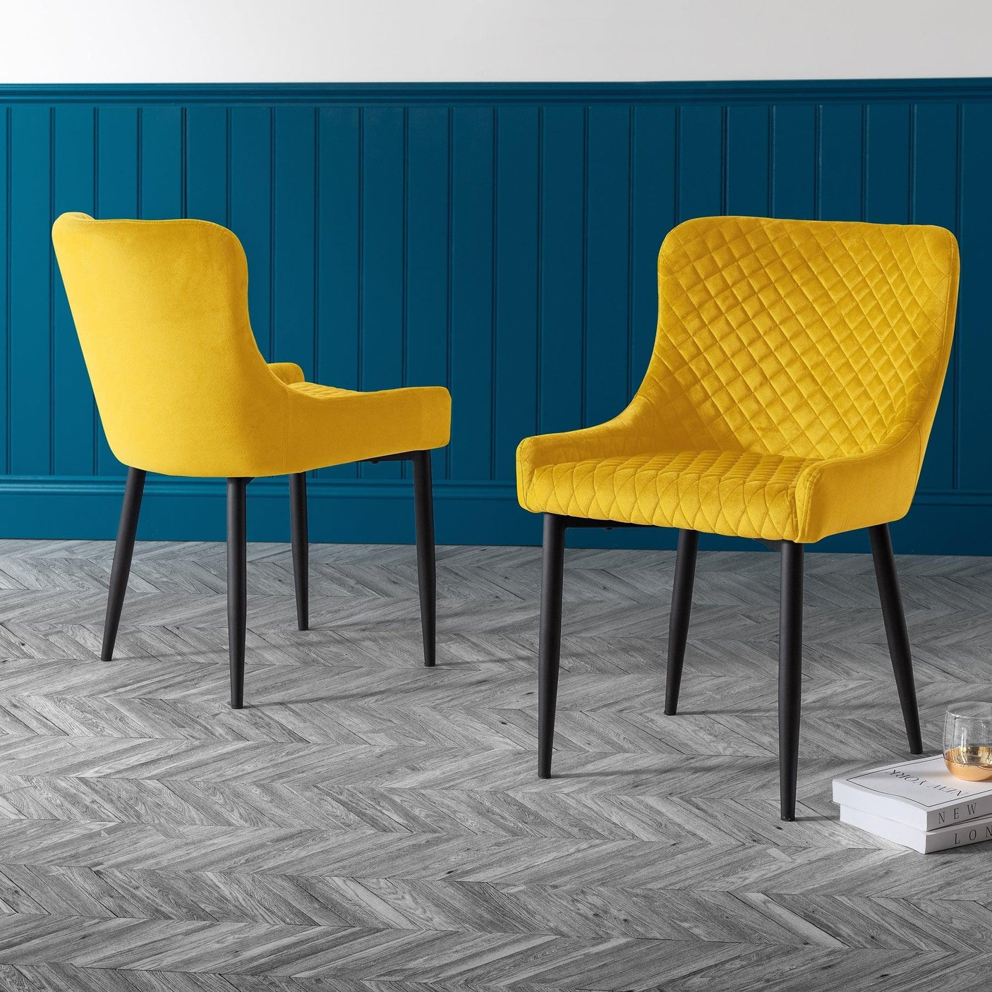 Mustard velvet dining chairs with black legs on chevron wood floor in modern dining room