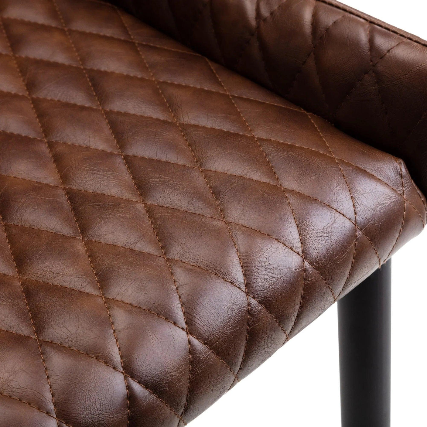 Brown faux leather dining chair with quilted seat detail and black metal leg closeup