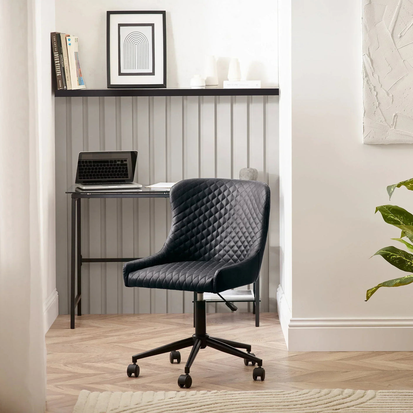 Black faux leather office chair with diamond stitching in a modern home workspace