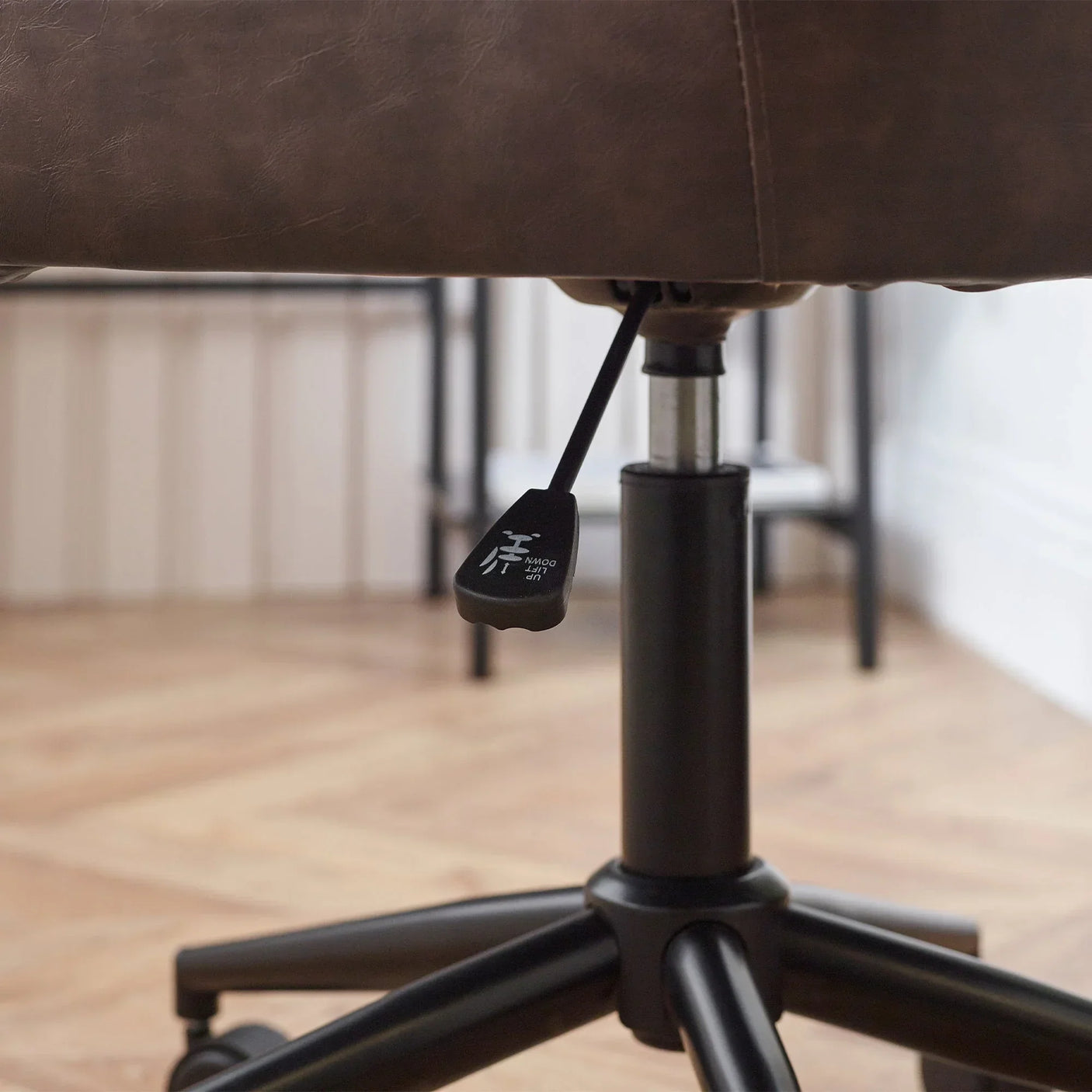 Brown faux leather office chair seat with height adjustment lever and black base detail