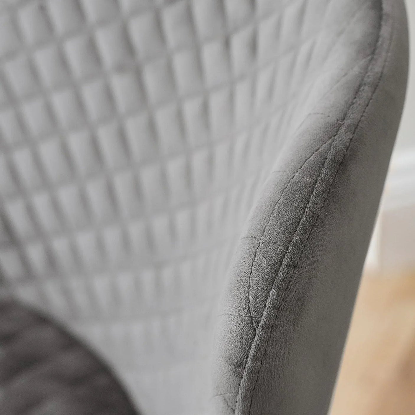 Close-up of grey velvet office chair backrest with quilted stitching detail
