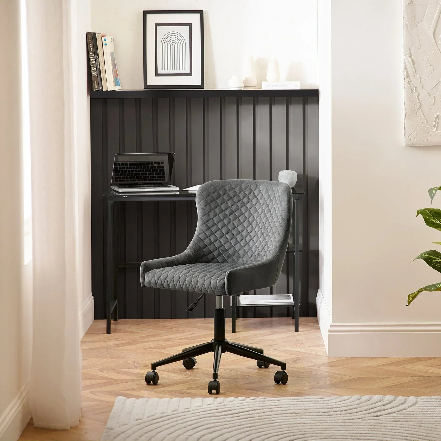 Grey velvet office chair with quilted seat on castors in a modern home workspace