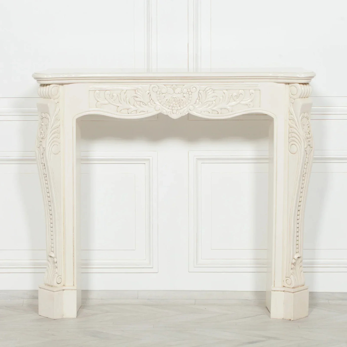 Cream console table with ornate carved detailing and curved legs against white panelled wall