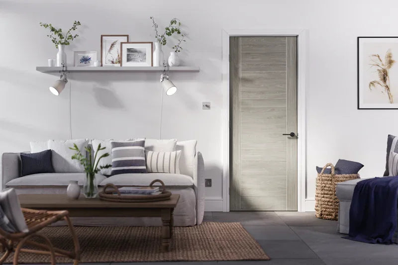 Light grey laminate door in modern living room with white sofa, coffee table, and wall decor