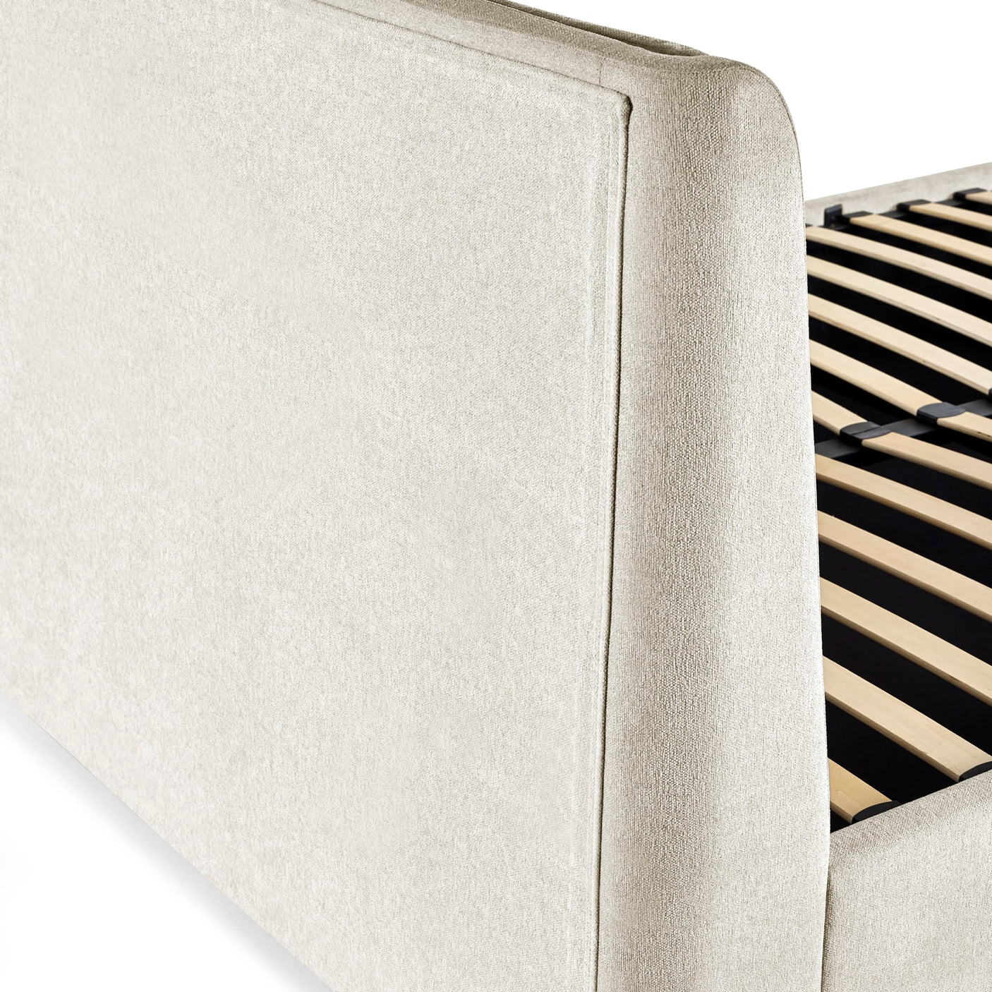 Close-up of beige textured upholstery on bed frame corner with slatted wooden base visible