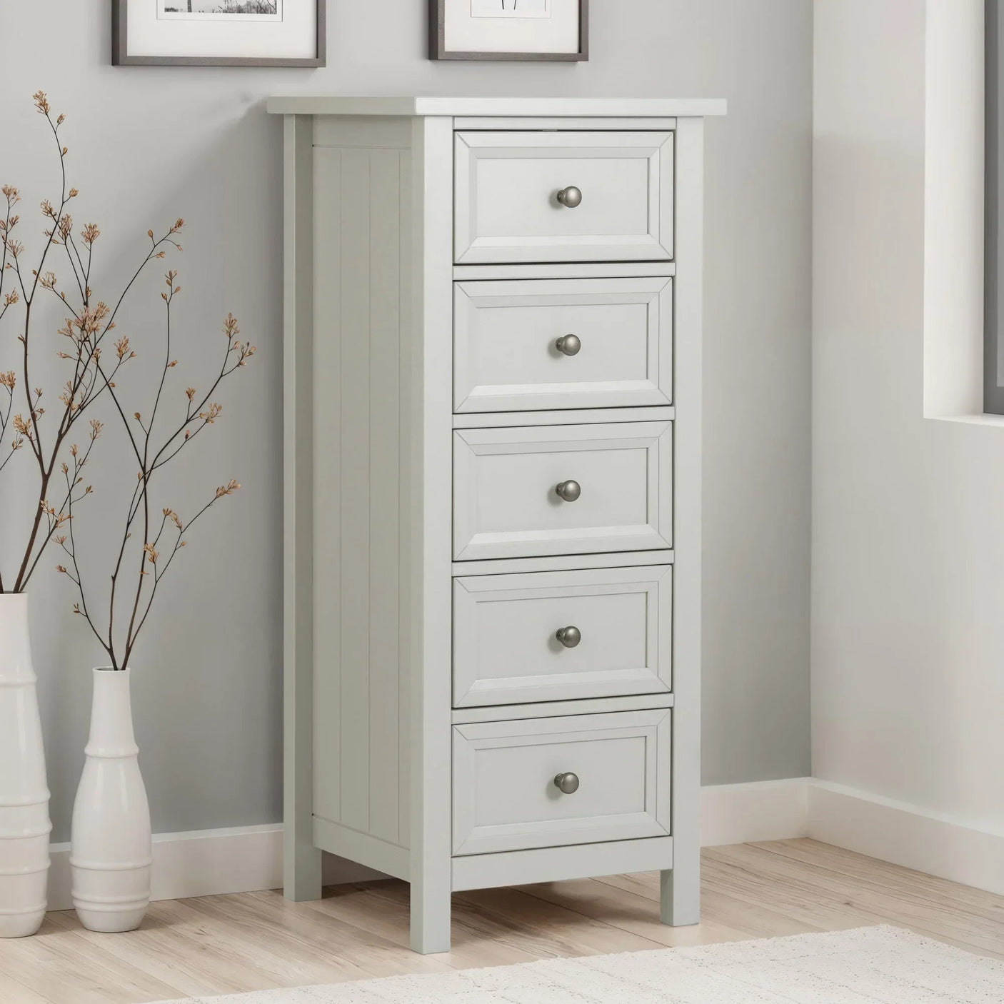 White tallboy chest of drawers with five drawers in modern bedroom corner