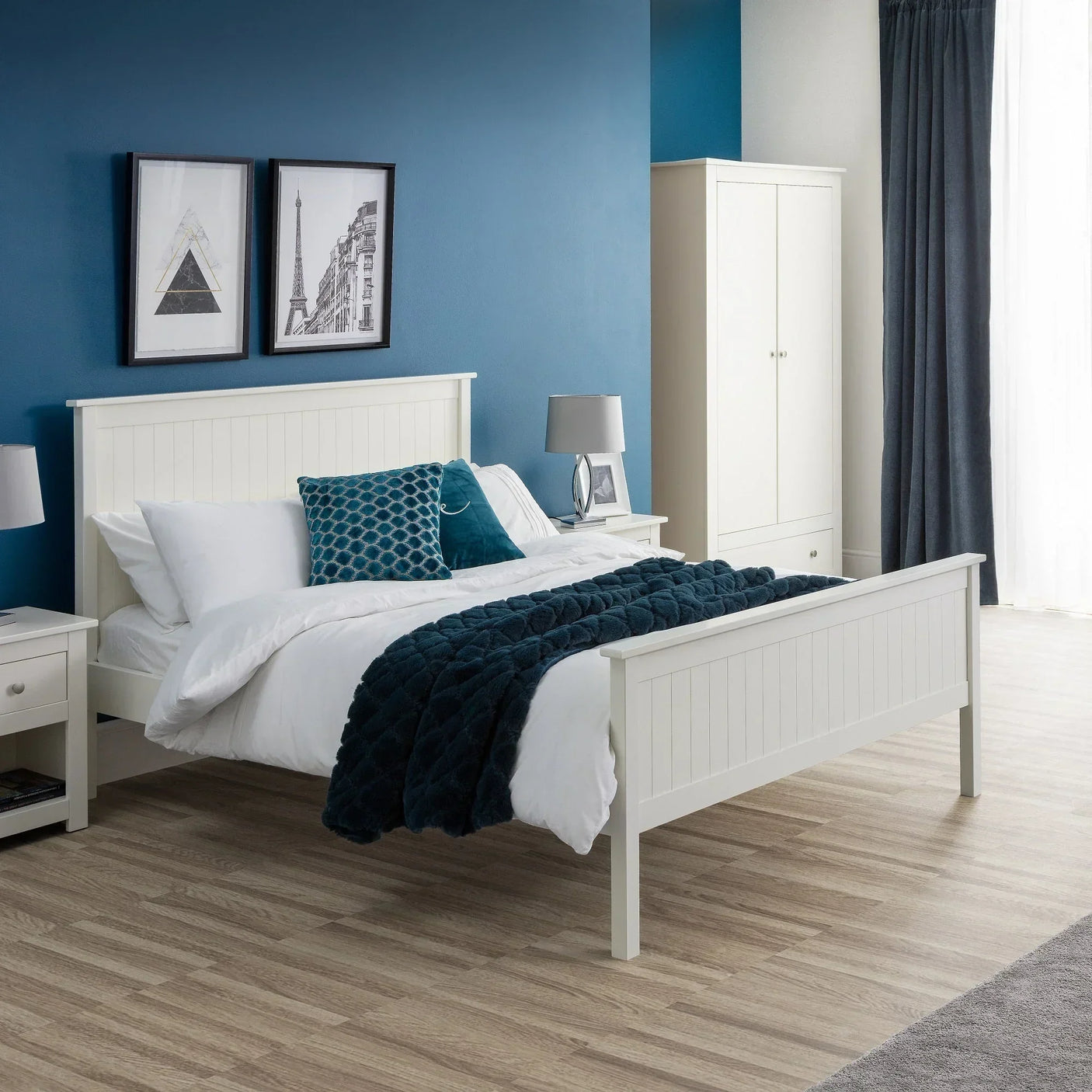 White wooden bed frame with white bedding and blue throw in modern bedroom setting