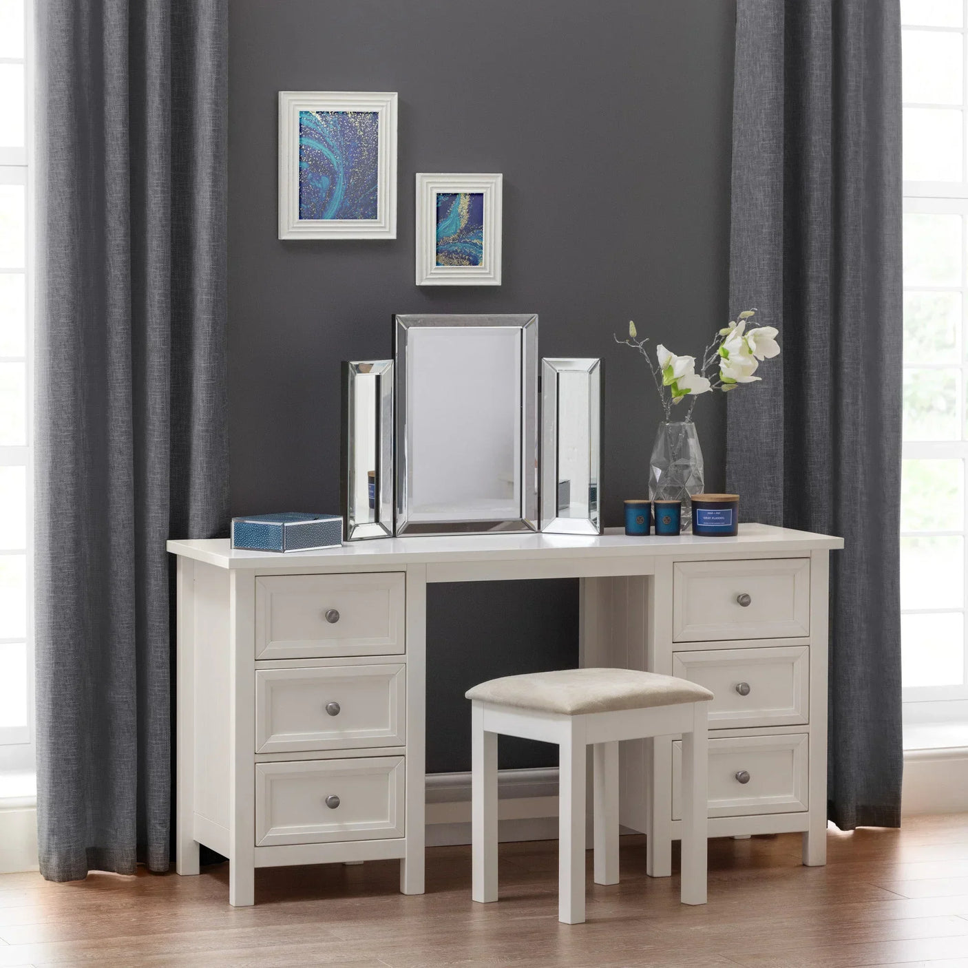 White dressing table with six drawers, triple mirror, cushioned stool and decorative accents