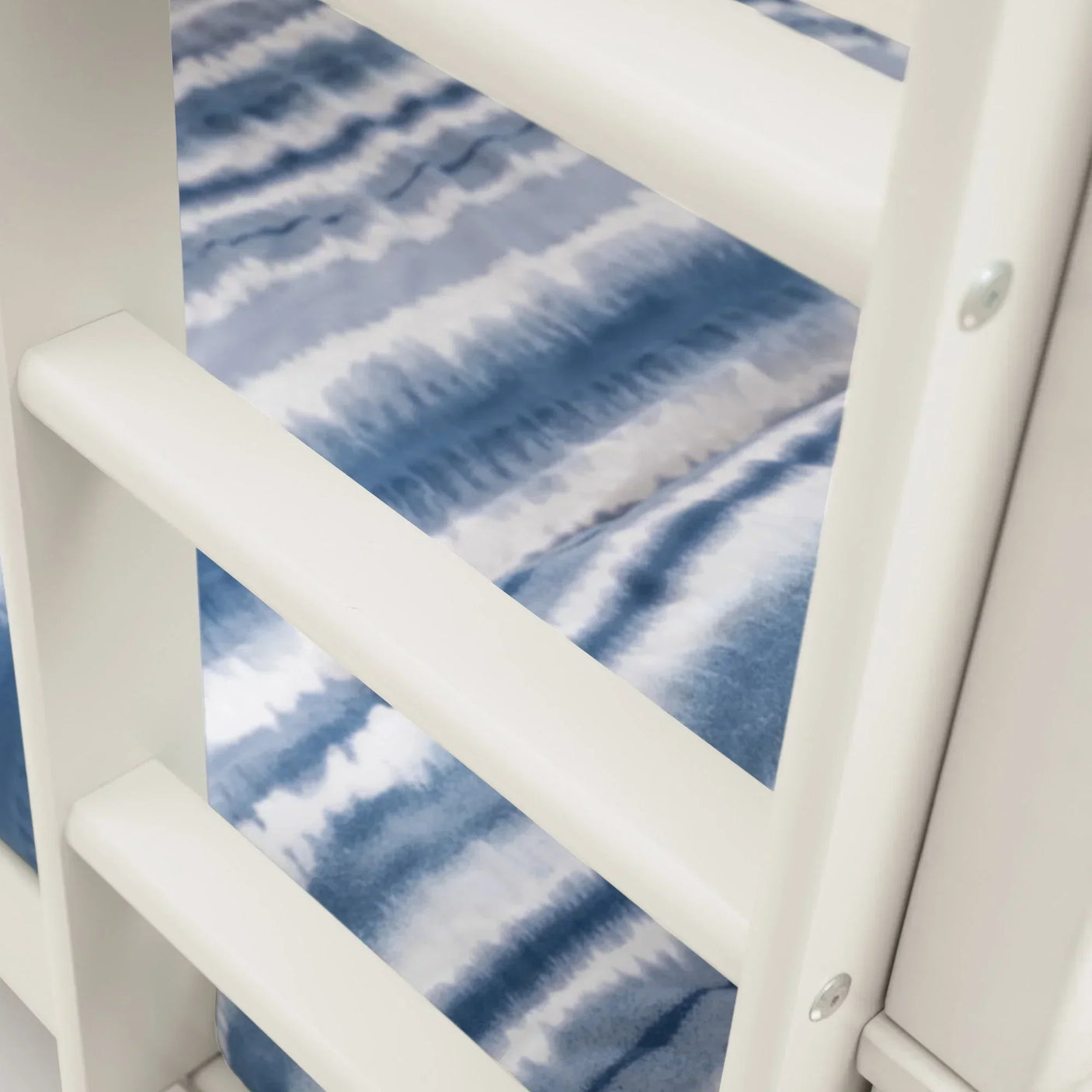 White bunk bed ladder with blue striped mattress visible behind rungs