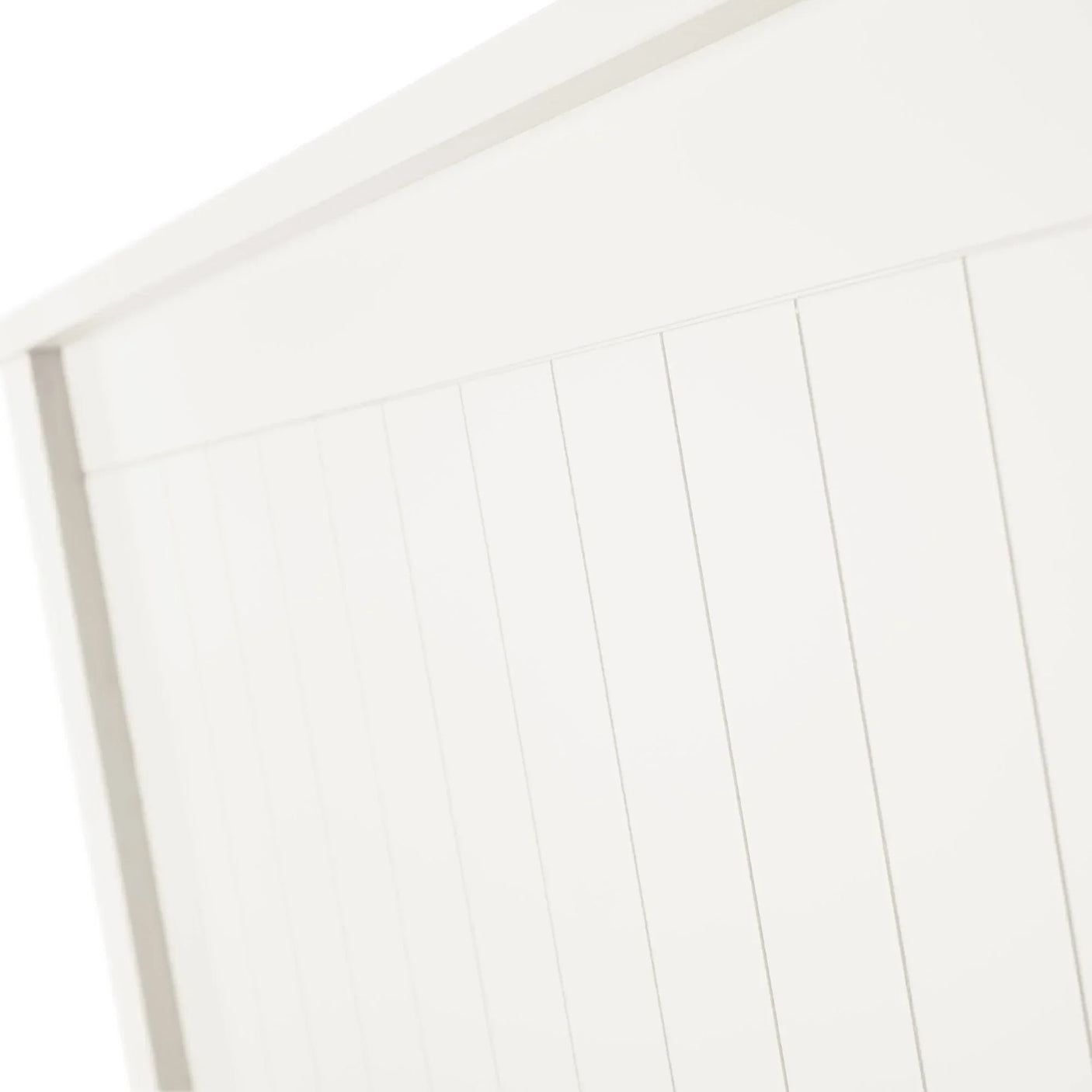 White wooden bed headboard with vertical panel detailing close-up