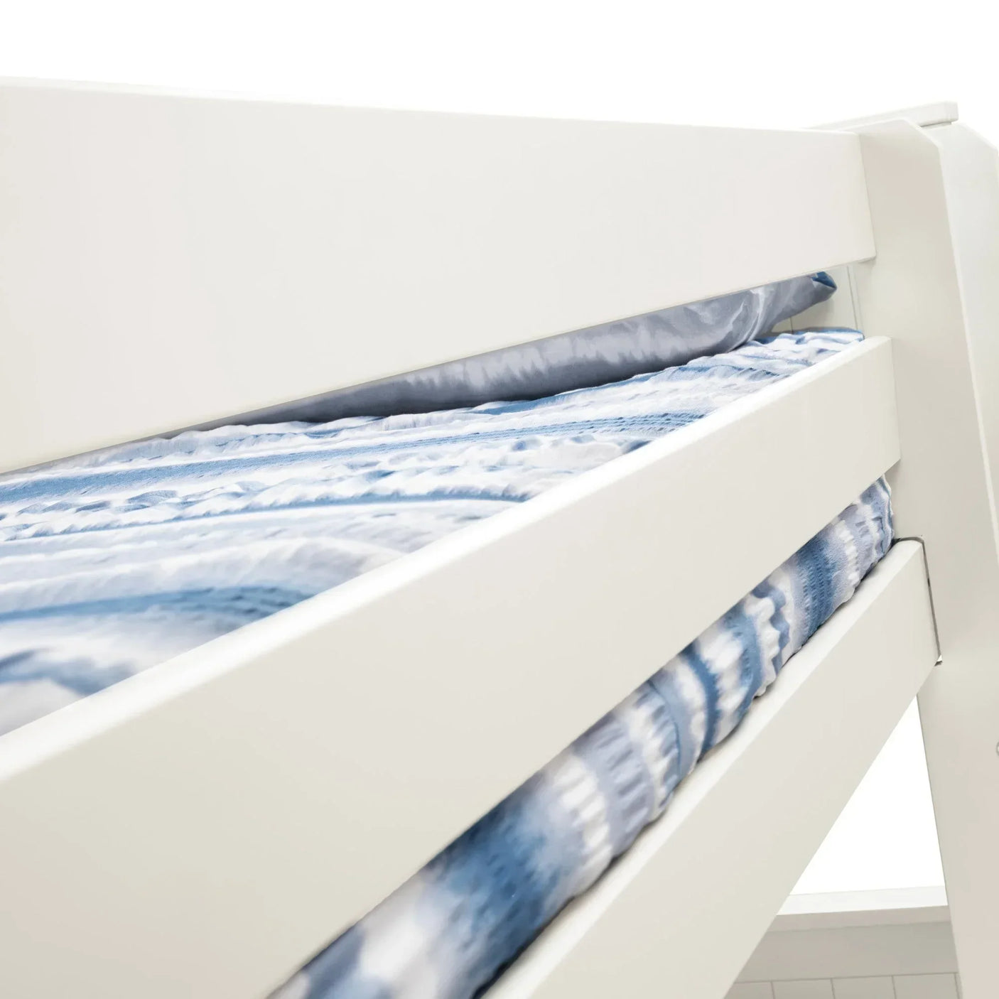 White wooden bunk bed with blue and white bedding, close-up of upper bunk guardrails