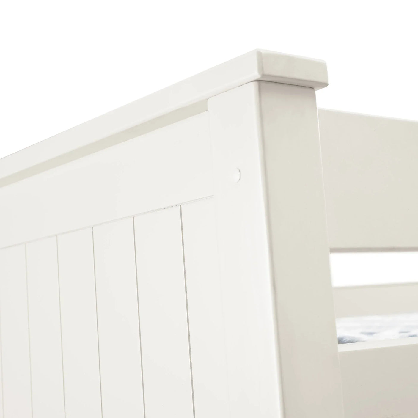 White wooden bunk bed headboard with vertical panel design, close-up angle