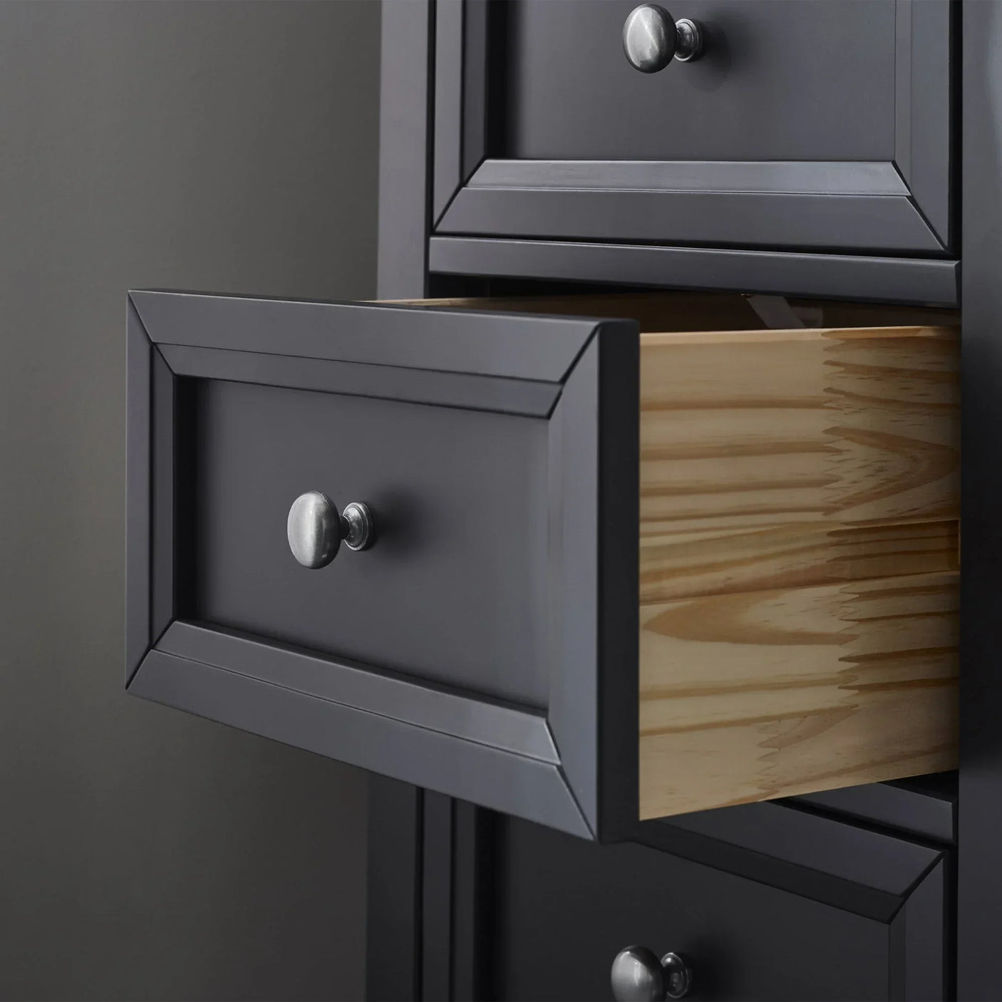 Anthracite tall chest of drawers with open wooden drawer and metal knob handles