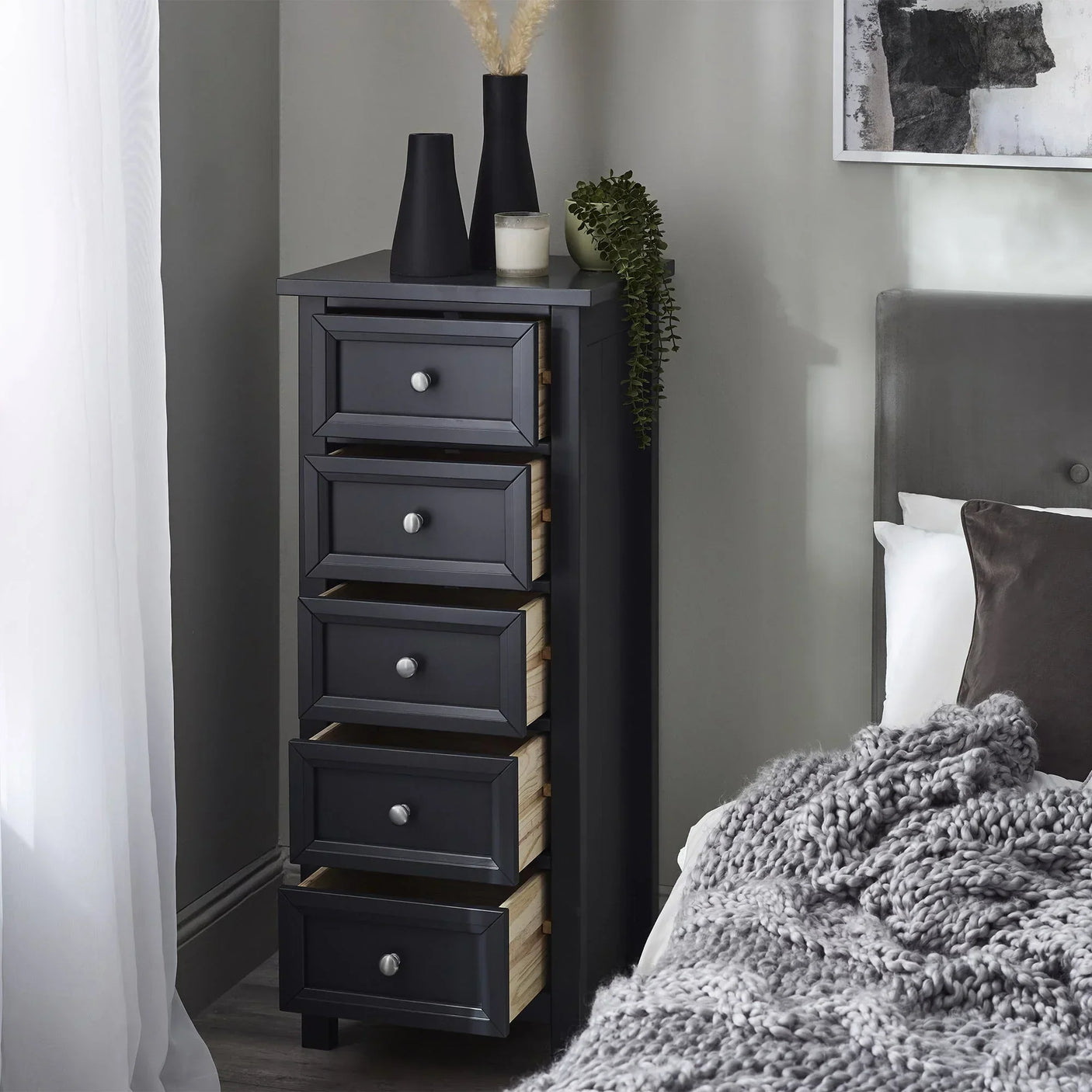 Anthracite five drawer tall chest in bedroom with grey bed and modern decor